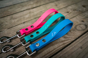 mini dog traffic leads three biothane color handles and silver clips on a wood background