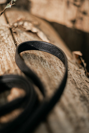 Close-up of Pebble Grip BioThane® leash on textured wood, showcasing its durable, raised grip design.