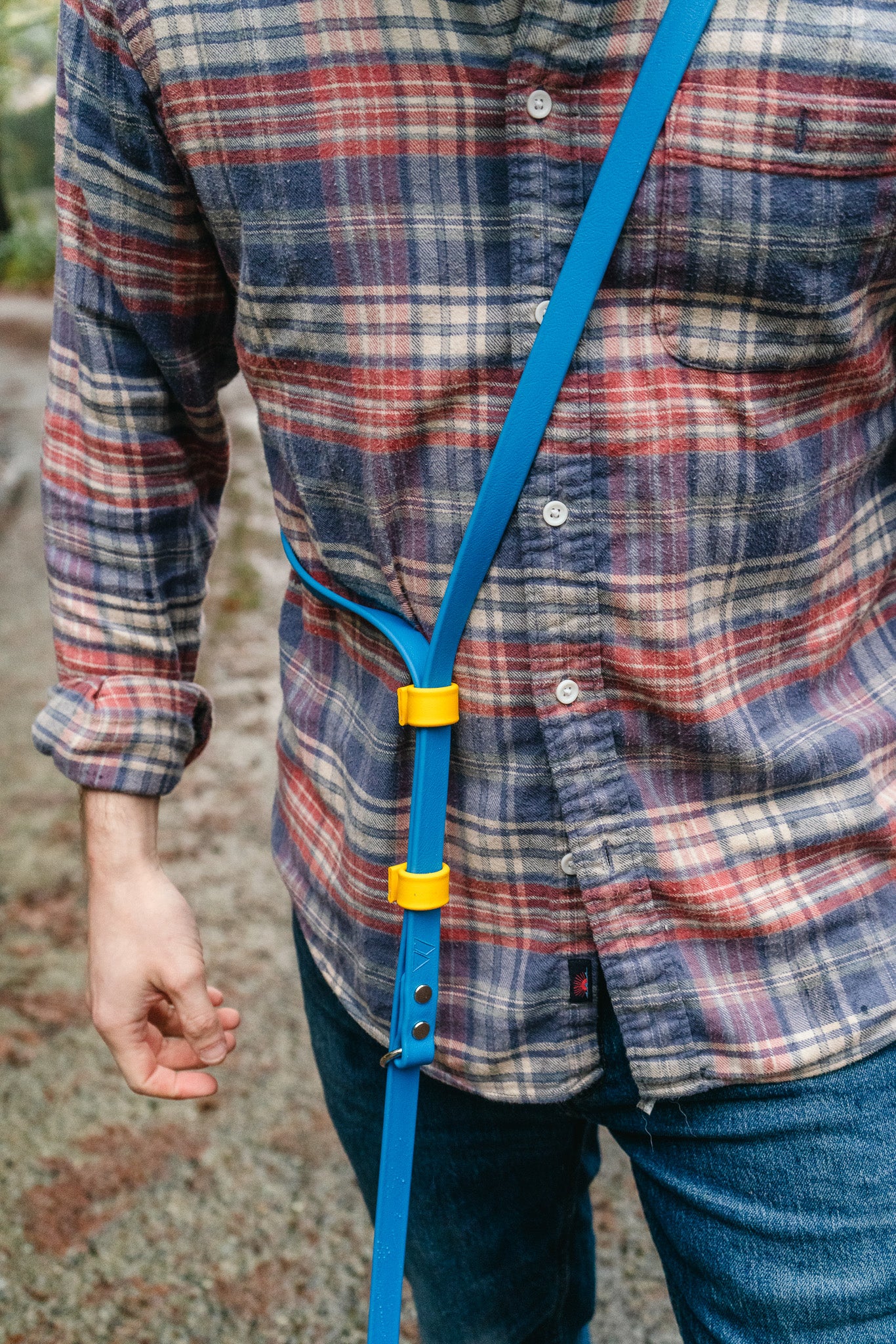 Eco adjustable length BioThane hands-free leash worn by a person, showcasing its minimalist design and functionality.